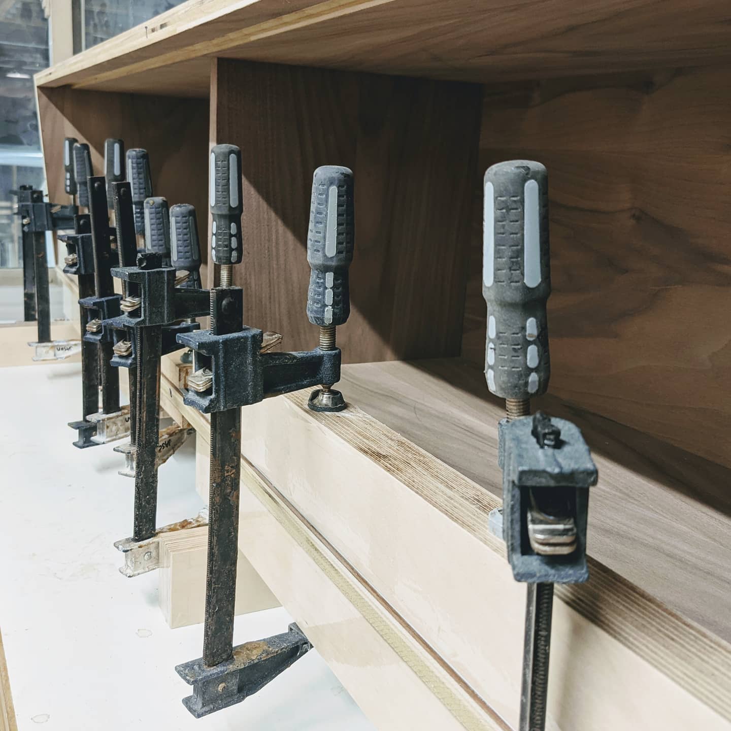 November 25th, 2020: We're in full swing on our next project! A walnut entertainment console designed by us! Today we fit, glued, and clamped the aluminum tracks for the sliding door hardware.